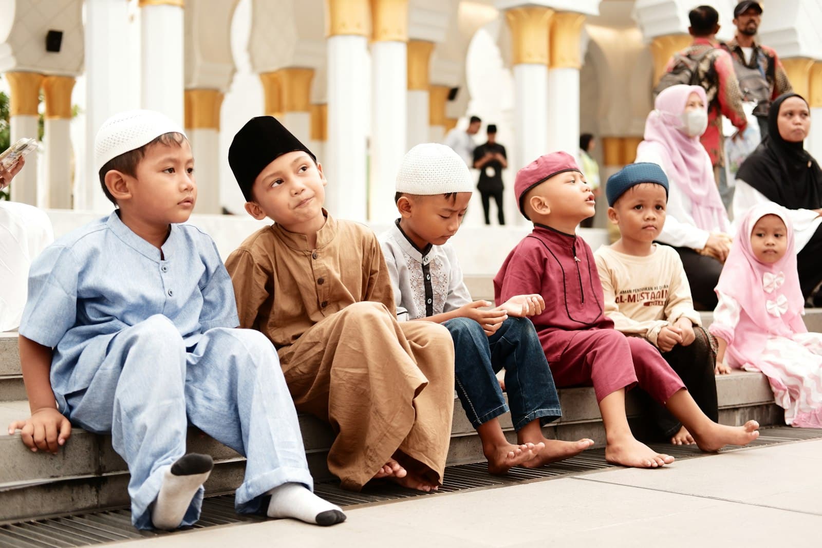 Young children sitting together outside a mosque