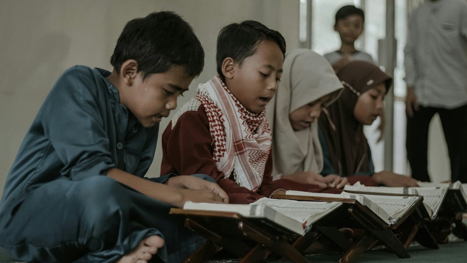 Children sitting together reading the Quran